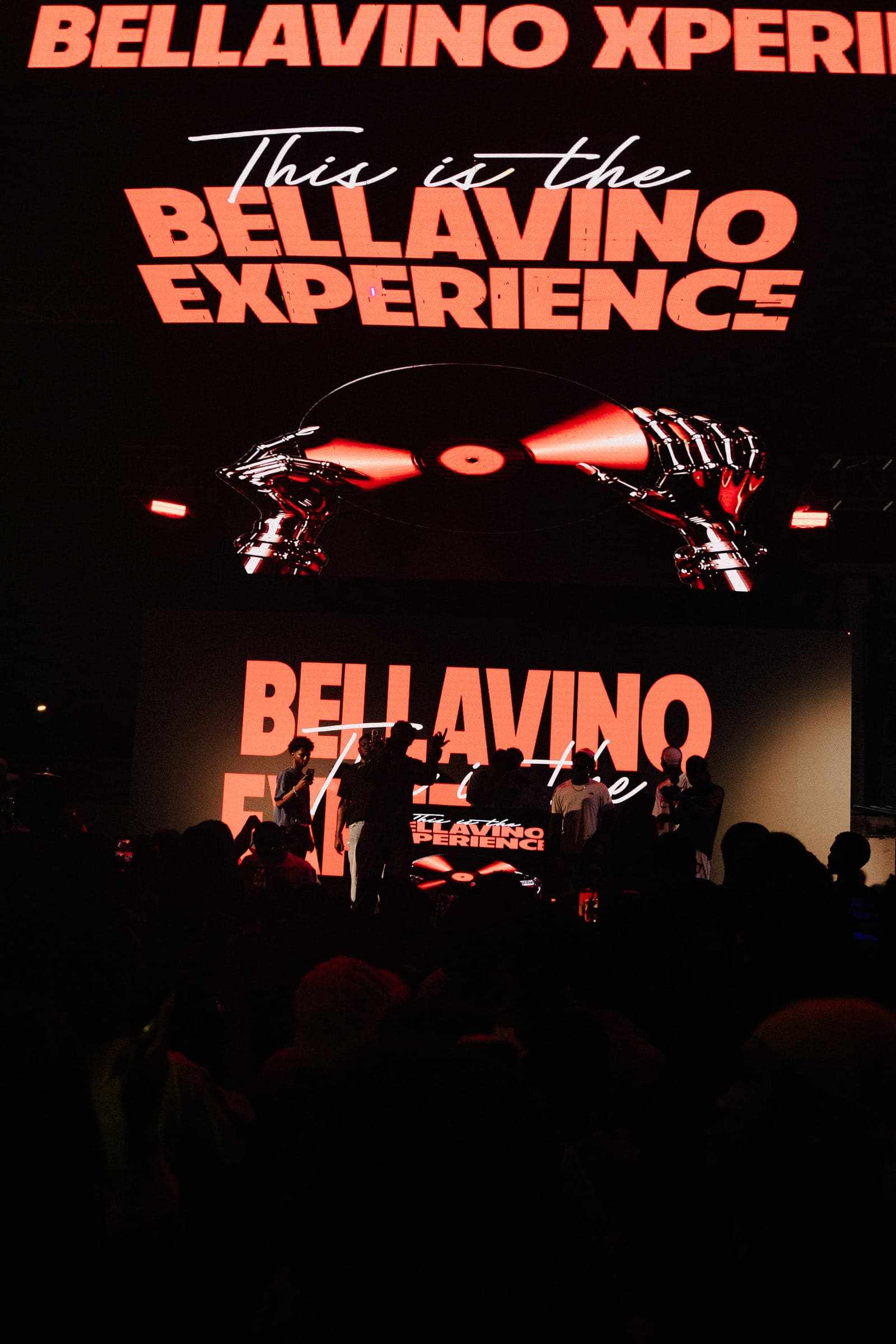 The giant LED screen reading This is the Bellavino Experience towers over the stage
