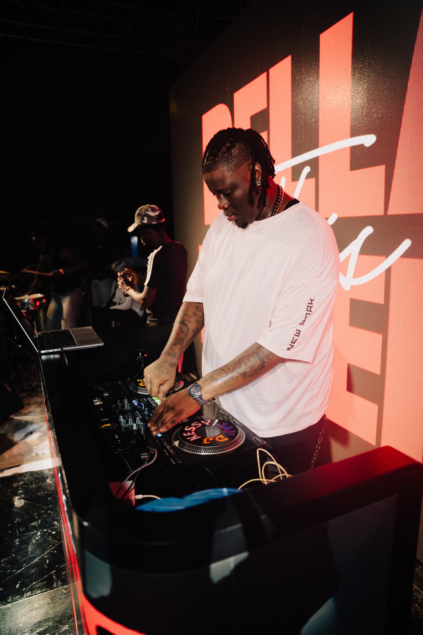 The DJ on the decks in front of the glowing BELLAVINO screen